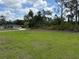 Expansive front yard with green grass and mature trees at 6179 Notre Dame Ter, North Port, FL 34291