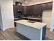 Modern kitchen with dark cabinetry, a granite island, and stainless steel appliances at 6179 Notre Dame Ter, North Port, FL 34291