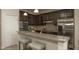 Modern kitchen featuring dark cabinetry, stainless steel appliances, granite countertops, and breakfast bar with seating at 6179 Notre Dame Ter, North Port, FL 34291