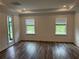 Spacious main bedroom with tray ceiling, a private patio entrance, and dark vinyl floors at 6179 Notre Dame Ter, North Port, FL 34291