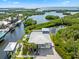 Stunning aerial view of a waterfront home with a metal roof surrounded by lush greenery and waterways at 24145 Blackbeard Blvd, Punta Gorda, FL 33955