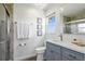 Bright bathroom with a blue vanity, white counter tops, and framed decorative art at 24145 Blackbeard Blvd, Punta Gorda, FL 33955