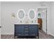 Bathroom featuring a blue double vanity with modern lighting and fixtures at 24145 Blackbeard Blvd, Punta Gorda, FL 33955
