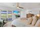 Serene bedroom with water views, a ceiling fan, light wood floors, and access to a private balcony at 24145 Blackbeard Blvd, Punta Gorda, FL 33955