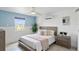 Bright bedroom featuring a queen-size bed, ceiling fan, and accent wall with a large window at 24145 Blackbeard Blvd, Punta Gorda, FL 33955