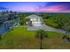 Aerial view of a lovely two-story home featuring a large front lawn, mature trees, and convenient water access at 24145 Blackbeard Blvd, Punta Gorda, FL 33955