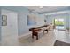 Spacious game room featuring a shuffleboard table, light blue walls and adjacent dining area at 24145 Blackbeard Blvd, Punta Gorda, FL 33955