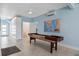 Game room with a shuffleboard table, blue walls, and access to stairs, with tiled floors at 24145 Blackbeard Blvd, Punta Gorda, FL 33955