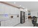 Modern kitchen features white cabinets, stainless steel refrigerator, and marble countertops at 24145 Blackbeard Blvd, Punta Gorda, FL 33955