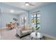 Inviting living room with blue walls, cozy seating, and views of the outdoor swimming pool at 24145 Blackbeard Blvd, Punta Gorda, FL 33955