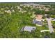 Aerial view of a home with a pool, surrounded by lush trees in a quiet neighborhood at 3008 Sutton Woods Dr, Plant City, FL 33566