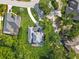 Aerial view of a well-maintained home with a screened-in pool and lush surroundings at 3008 Sutton Woods Dr, Plant City, FL 33566