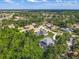 Aerial view of a home with a pool in a lush, wooded neighborhood at 3008 Sutton Woods Dr, Plant City, FL 33566