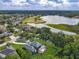 Aerial view of a home with a pool, nestled near a serene lake and golf course at 3008 Sutton Woods Dr, Plant City, FL 33566