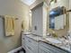 Bathroom featuring double sinks, granite countertops, and a decorative mirror with storage space at 3008 Sutton Woods Dr, Plant City, FL 33566
