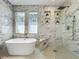 Contemporary bathroom featuring a freestanding tub, walk-in shower, and marble tile at 3008 Sutton Woods Dr, Plant City, FL 33566