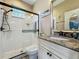Modern bathroom boasts a tiled shower with sleek fixtures, granite counters, stylish mirror, and a comfort-height toilet at 3008 Sutton Woods Dr, Plant City, FL 33566