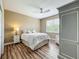 Bedroom featuring a comfortable bed with stylish bedding, complemented by a ceiling fan and wood floors at 3008 Sutton Woods Dr, Plant City, FL 33566