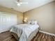 Comfortable bedroom features a ceiling fan, closet, and a comfortable bed with decorative pillows and wood floors at 3008 Sutton Woods Dr, Plant City, FL 33566
