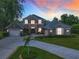 Stately two-story home with stone accents, double front doors, and lush landscaping at 3008 Sutton Woods Dr, Plant City, FL 33566