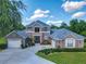 Beautiful two-story home featuring a lush lawn, curved driveway, and a three-car garage at 3008 Sutton Woods Dr, Plant City, FL 33566