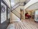 Grand foyer with a decorative glass door, staircase with iron railings and hardwood floors and a grand piano at 3008 Sutton Woods Dr, Plant City, FL 33566