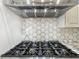 The kitchen features a modern gas stovetop, stainless steel hood, and contemporary tile backsplash at 3008 Sutton Woods Dr, Plant City, FL 33566