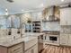 Kitchen boasts a modern island with granite countertops, stylish lighting, and stainless steel appliances at 3008 Sutton Woods Dr, Plant City, FL 33566