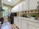 Bright laundry room with granite counters, plenty of cabinet space, modern washer/dryer, and a window view at 3008 Sutton Woods Dr, Plant City, FL 33566