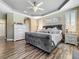 Inviting main bedroom featuring wood floors, tray ceilings, and plantation shutters at 3008 Sutton Woods Dr, Plant City, FL 33566