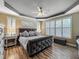Inviting main bedroom featuring wood floors, tray ceilings, and plantation shutters at 3008 Sutton Woods Dr, Plant City, FL 33566