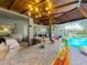 View of an outdoor kitchen, the pool, a patio area and stylish seating at 3008 Sutton Woods Dr, Plant City, FL 33566
