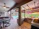 Outdoor kitchen with a stainless steel BBQ, a wet bar, an umbrella covered table and view of the pool at 3008 Sutton Woods Dr, Plant City, FL 33566