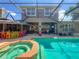 Enjoy outdoor entertaining with this screened-in pool, spa, outdoor kitchen, and patio seating area at 3008 Sutton Woods Dr, Plant City, FL 33566