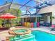 Enjoy outdoor entertaining with this screened-in pool, spa, outdoor kitchen, and patio seating area at 3008 Sutton Woods Dr, Plant City, FL 33566
