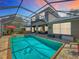 Enjoy outdoor entertaining with this screened-in pool, spa, outdoor kitchen, and patio seating area at 3008 Sutton Woods Dr, Plant City, FL 33566