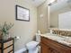 Elegant powder room featuring granite counters, wood vanity, and decorative mirror at 3008 Sutton Woods Dr, Plant City, FL 33566