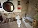 Bathroom featuring tiled walls, a large round mirror, and a shower and bath combination at 560 7Th S St, Safety Harbor, FL 34695