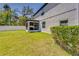 Spacious backyard featuring a well-maintained lawn, shrubbery, and a screened porch at 5703 New Paris Way, Ellenton, FL 34222