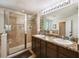 Bathroom with granite countertops, dual sinks, and a glass-enclosed tiled shower at 5703 New Paris Way, Ellenton, FL 34222