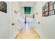 Hallway has multiple doors leading to pantry, bathroom, etc., with neutral-toned walls and tiled floors at 5703 New Paris Way, Ellenton, FL 34222