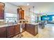 Modern kitchen featuring dark cabinetry, granite countertops, and an open layout with views to the dining room at 5703 New Paris Way, Ellenton, FL 34222