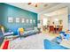 Comfortable seating area with colorful decor, including a blue sofa and a view into the dining room at 5703 New Paris Way, Ellenton, FL 34222