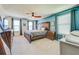 Spacious main bedroom featuring a stylish wooden headboard, three windows, and modern furnishings at 5703 New Paris Way, Ellenton, FL 34222
