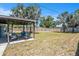 Large backyard featuring a patio, luscious green grass, palm trees, and a wooden fence at 6801 16Th N St, St Petersburg, FL 33702
