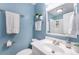 Bathroom with blue walls, a white sink and vanity, plus a decorative mirror at 6801 16Th N St, St Petersburg, FL 33702