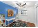 Inviting bedroom area with desk, chair, shelving and bright blue accent wall at 6801 16Th N St, St Petersburg, FL 33702