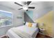 Bright bedroom featuring a ceiling fan, natural light from the window, and a bed with colorful accents at 6801 16Th N St, St Petersburg, FL 33702