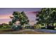 Inviting blue single-story home at dusk, complete with carport and mature landscaping in a tranquil setting at 6801 16Th N St, St Petersburg, FL 33702