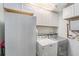 Functional laundry area with white appliances, storage cabinets, and modern features at 6801 16Th N St, St Petersburg, FL 33702